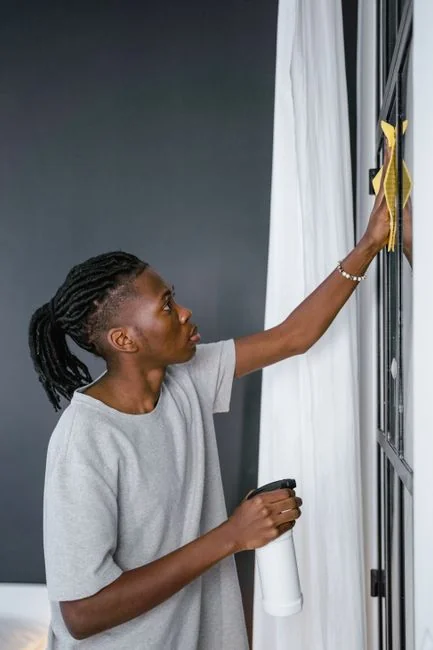 creative-03 Une équipe de nettoyage en tenue rouge, munie de matériel, s’approche de l’extérieur d’une maison moderne.